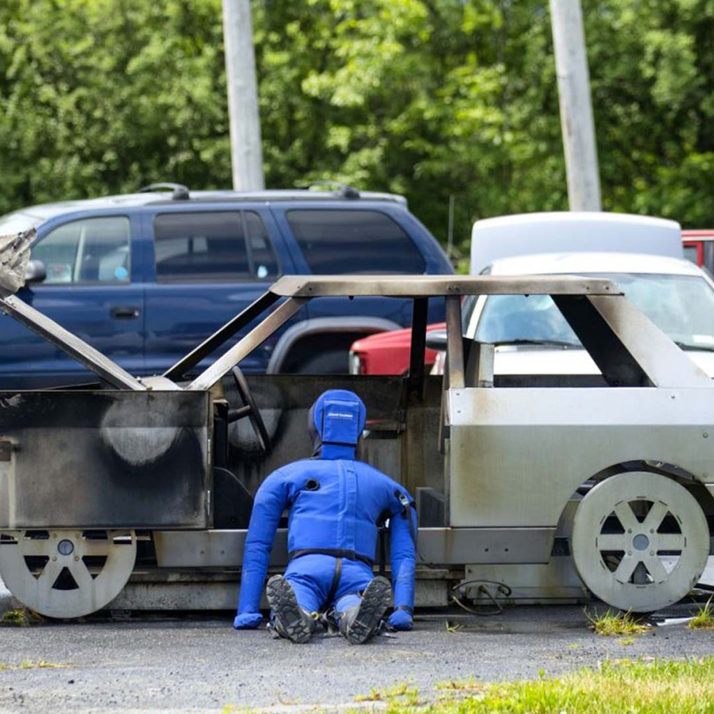 LION® SmartDummy™ Extrication sitting next to a training vehicle